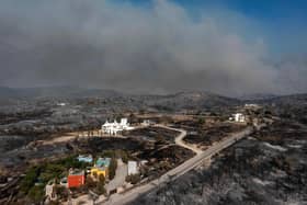 Tens of thousands of people have already fled blazes on the island of Rhodes, with many frightened tourists scrambling to get home (Picture: Spyros Bakalis/AFP/Getty Images)
