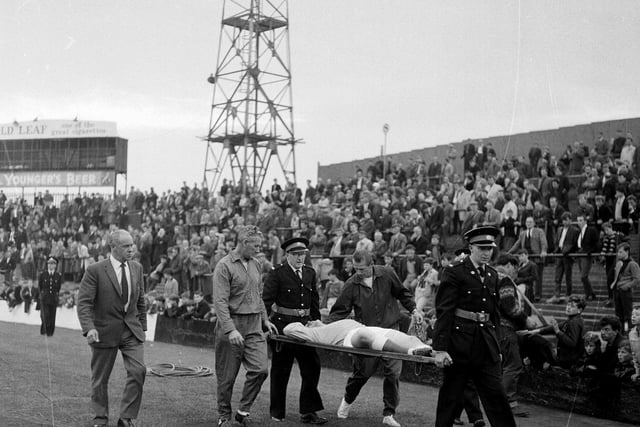 Hibs goalkeeper Willie Wilson is pictured being stretchered off the pitch during a Hibernian v St Mirren game at Easter Road in August 1965.