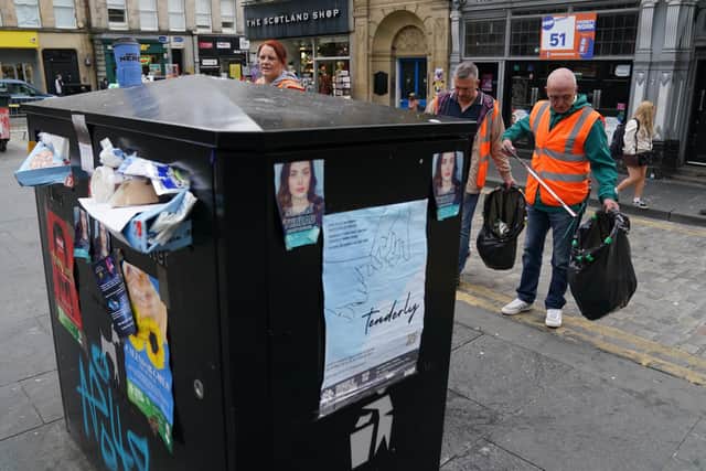 People pick up rubbish in Edinburgh city centre as cleansing workers take strike action (Picture: Andrew Milligan/PA)