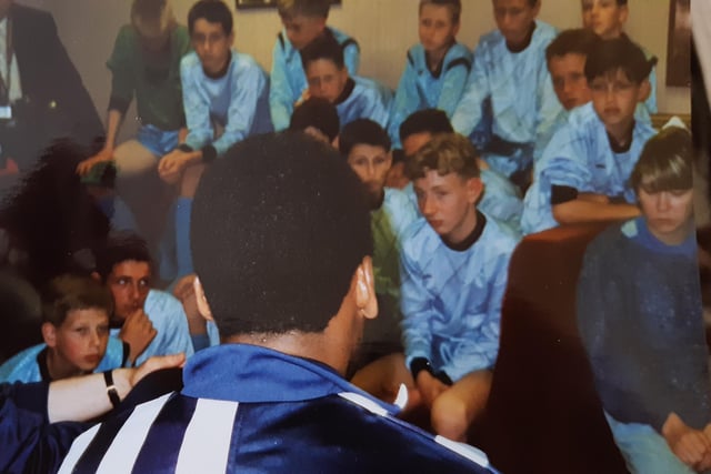 Pele, with his back to the camera, taking questions from the awe inspired Craigmount High footballers.