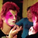 David Bowie applying his Ziggy Stardust makeup in the 1970s. Picture: R Bamber/Rex Features