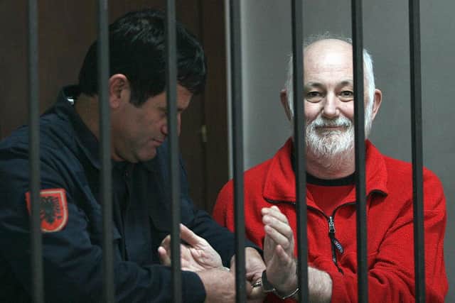 A Police officer remove the handcuffs from Britton David Brown, 57, before the verdict in court, where he was sentenced him to 20 years in jail for sexually abusing minors, in Tirana on November 19, 2008. Picture: GENT SHKULLAKU/AFP via Getty Images