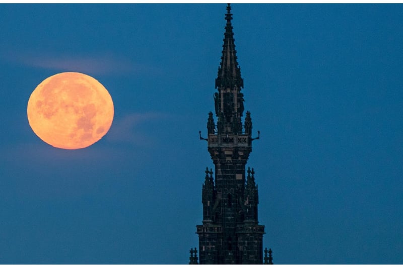 The supermoon sets behind the Scott Monument in Edinburgh.