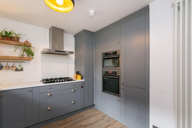 To the front is a stylish kitchen with quartz worktops, a Belfast-style ceramic sink; and an integrated dishwasher, washer/dryer, fridge/freezer, oven, microwave combi oven, and a 5-ring gas hob with a canopy above.