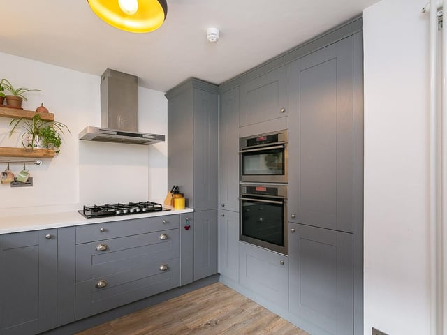 To the front is a stylish kitchen with quartz worktops, a Belfast-style ceramic sink; and an integrated dishwasher, washer/dryer, fridge/freezer, oven, microwave combi oven, and a 5-ring gas hob with a canopy above.