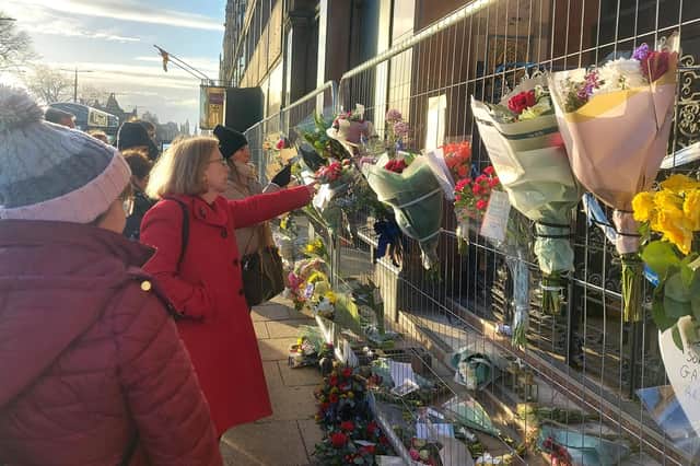 Members of the public pay their respects with flower displays and messages to tribute Barry Martin.