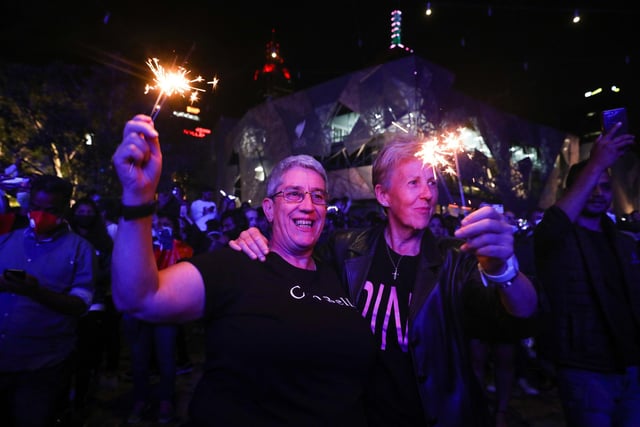 People with sparklers lit up celebrate the New Year at Federation Square during New Year's Eve celebrations on January 1, 2021 in Melbourne, Australia. Celebrations look different this year as COVID-19 restrictions remain in place due to the ongoing coronavirus pandemic.