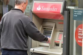 A man using a cash machine outside a branch of Santander in central London. Santander has announced it will be permanently closing 111 branches in the UK picture: John Stillwell/PA