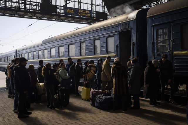 Ukrainians escaping from the besieged city of Mariupol along with other passengers from Zaporizhzhia gather on a train station platform after arriving at Lviv, western Ukraine, on Sunday, March 20, 2022. (AP Photo/Bernat Armangue)