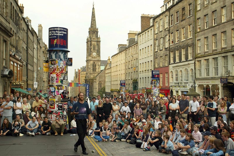 A street performer entertains the crowd on the Royal Mile during the 57th Edinburgh Festival Fringe on August 5, 2003. 
Photo by Scott Barbour/Getty Images.