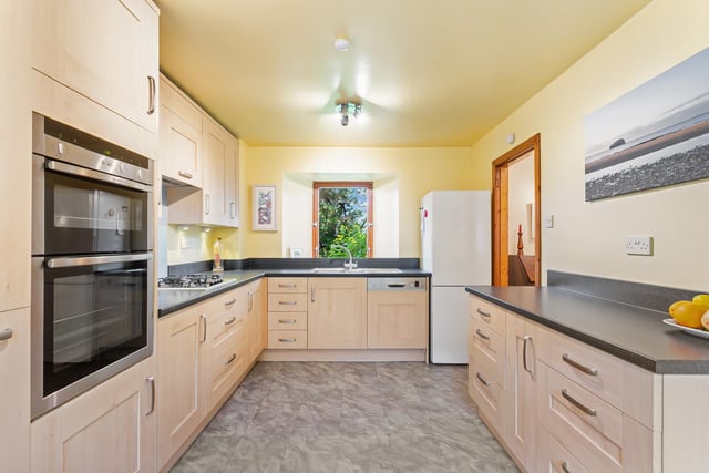 The double-aspect kitchen is equipped with a wide range of attractive, modern wood-styled cabinetry, spacious worktops, and integrated appliances comprising a double oven, a gas hob, and an extractor hood, whilst a freestanding washing machine and fridge/freezer are included in the sale. Space is also provided for a breakfasting area, catering for morning coffee, busy weekday breakfasts, and socialising while cooking.