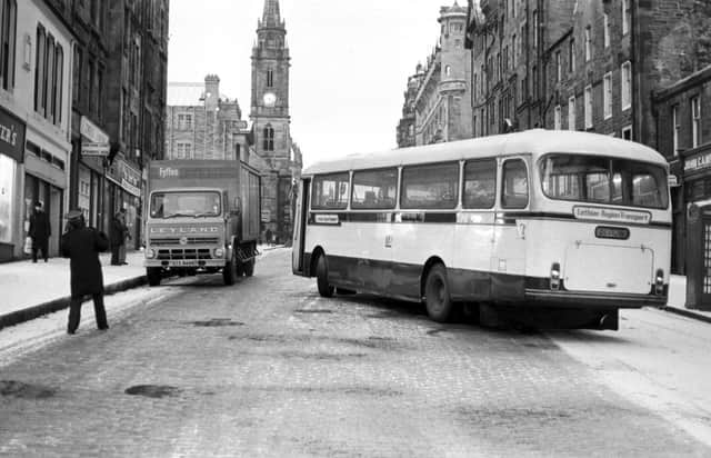 A Lothian Region Transport bus slips on the snow and gets stuck across the High Street Royal Mile Edinburgh, during the winter of 1979.