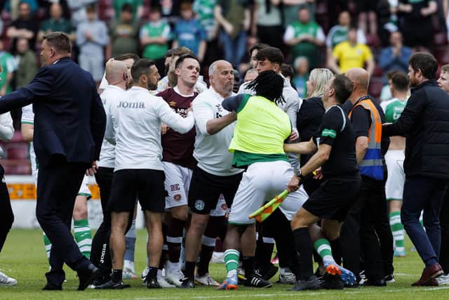 Hibs substitute Rocky Bushiri clashes with Hearts players at full time at Tynecastle.
