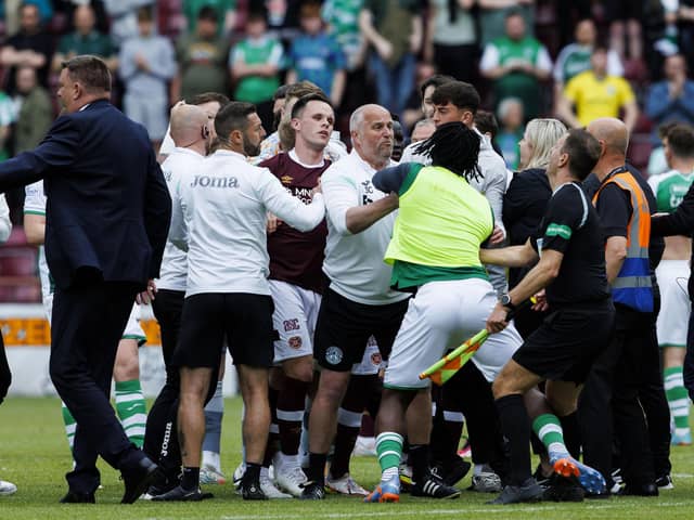Hibs substitute Rocky Bushiri clashes with Hearts players at full time at Tynecastle.