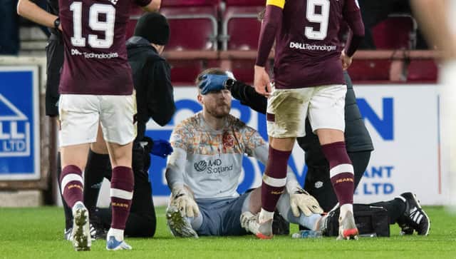 Hearts goalkeeper Zander Clark recieves treatment after being hit by an object from the crowd during the 3-0 win over Hibs. (Photo by Mark Scates / SNS Group)