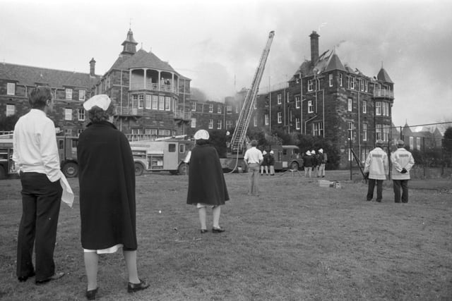Doctors and nurses watch as a fireman on a ladder hoses the roof of City Hospital in Edinburgh, when fire destroyed the Nurses' Home and the bell tower in November 1988.