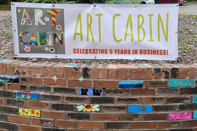 The decorated bricks with Art Cabin artwork on the roundal in Roslin Glen Country Park car park.