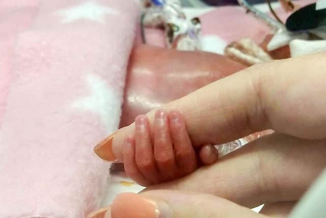 Aurora Devine at four hours old holds mum Stacey's finger. Pic: Contributed