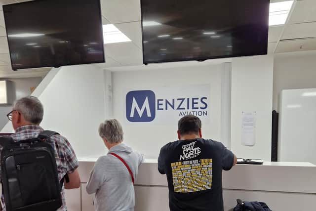 Passengers filling in missing baggage forms at an unstaffed Menzies Aviation desk at Edinburgh Airport. (Photo by Martina Ruch)