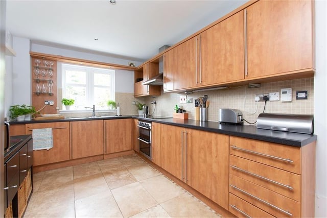 Fitted kitchen with contemporary units and worktops and integrated appliances.