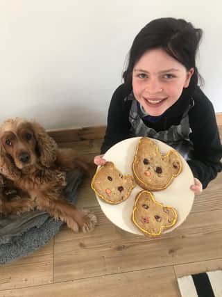 Helped by her baking assistant Otis the cocker spaniel Amber Redpath has designed dog-shaped biscuits to sell for charity.