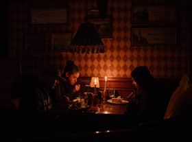 Visitors eating lunch by candlelight due to a power cut at a bar