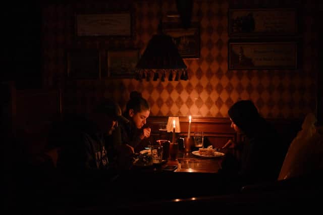 Visitors eating lunch by candlelight due to a power cut at a bar