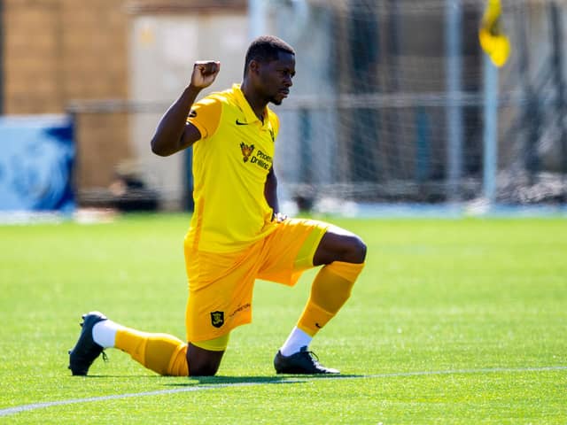 Livingston midfielder Marvin Bartley supports football's anti-racism movement by taking a knee ahead of a match this season. Photo by Ross MacDonald / SNS Group