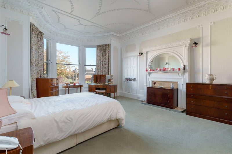 The master bedroom comes with a bay window, fireplace surround and ornate ceiling cornicing.