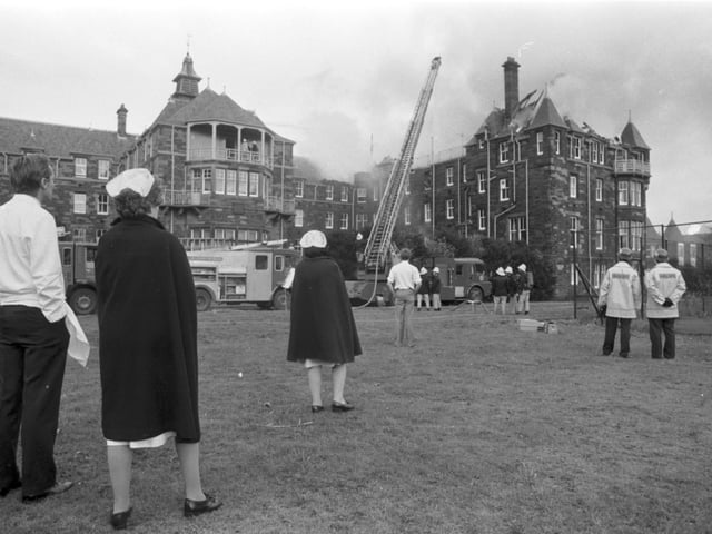 Doctors and nurses watch as a fireman on a ladder hoses the roof of City Hospital in Edinburgh, when fire destroyed the Nurses' Home and the bell tower in November 1988.