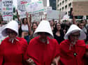 Abortion rights activists, dressed in an outfits from The Handmaid's Tale, lead protestors during a march in Denver, Colorado, after the US Supreme Court ruling (Picture: Jason Connolly/AFP via Getty Images)
