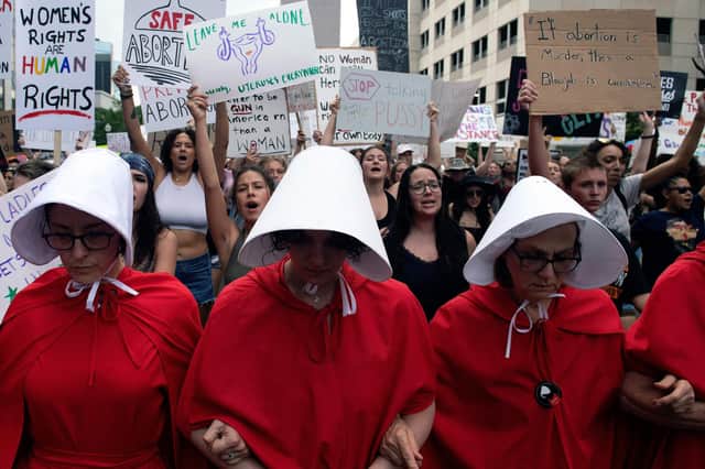 Abortion rights activists, dressed in an outfits from The Handmaid's Tale, lead protestors during a march in Denver, Colorado, after the US Supreme Court ruling (Picture: Jason Connolly/AFP via Getty Images)