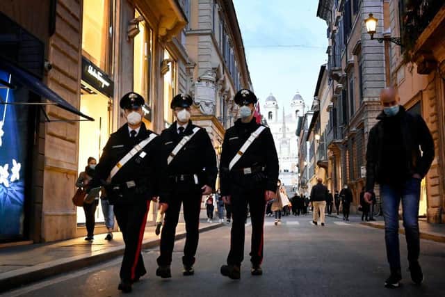 Police officers walk across the Via dei Condotti luxury shopping street in downtown Rome on 13 March, before the government tightened restrictions across most of the country from 15 March (Photo: Alberto PIZZOLI / AFP) (Photo by ALBERTO PIZZOLI/AFP via Getty Images)