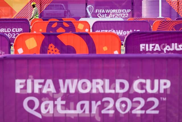 A worker walks past FIFA World Cup banners outside the Khalifa Stadium in Doha. Picture: KIRILL KUDRYAVTSEV/AFP via Getty