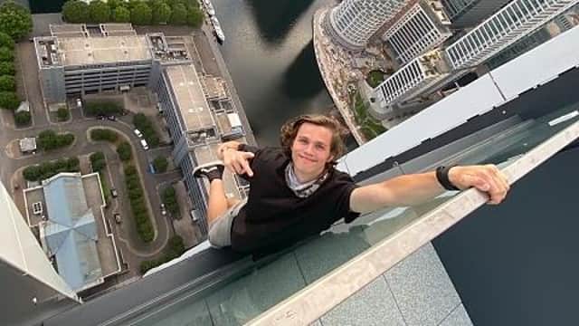 Adam Lockwood hangs one-handed from the ledge of a London skyscraper.