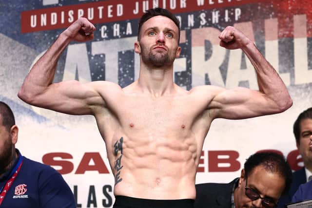 Undisputed super lightweight champion Josh Taylor flexes on the scale during the weigh in with Jack Catterall prior to their world championship bout