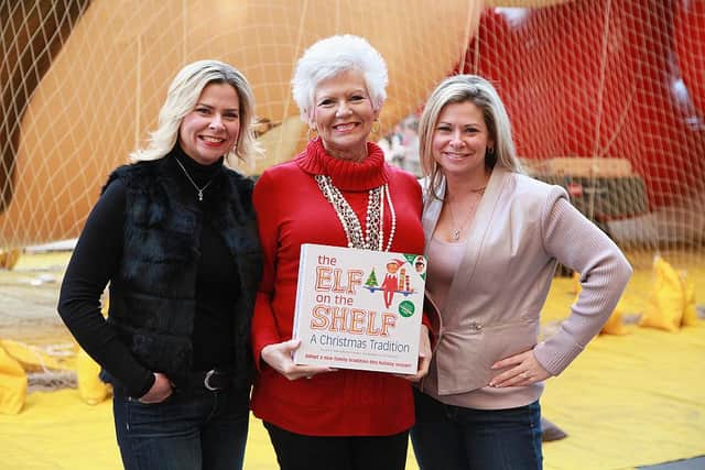 Twin sisters Chanda Bell (L) and Christa Pitts (R) celebrate with their mother, The Elf on the Shelf co-author Carol Aebersold. (Pic: Getty)