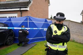 Officers from Police Scotland outside the Glasgow home of Peter Murrell and Nicola Sturgeon, where a blue police tent was erected in the front garden.