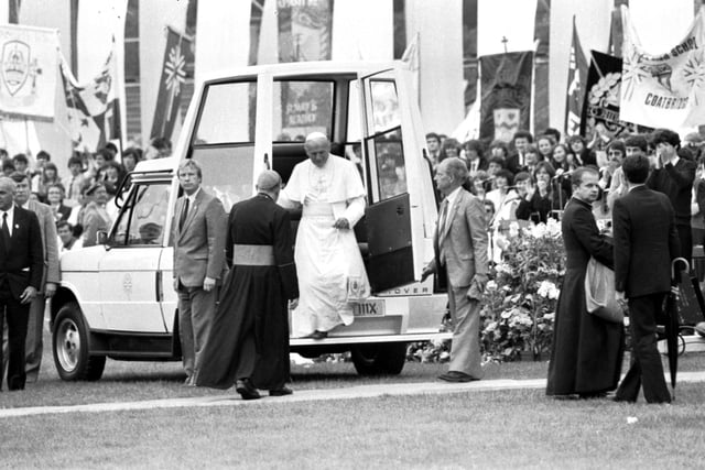 Pope John Paul II steps down from the 'Popemobile' at Murrayfield Stadium.