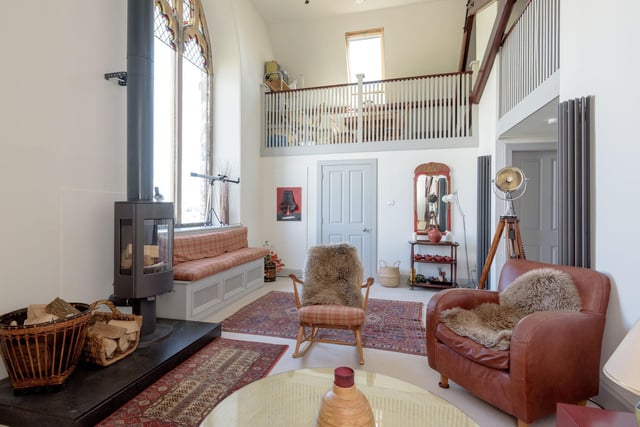 The second floor sitting room benefits from double height ceilings, lovely open views and a wood burning stove