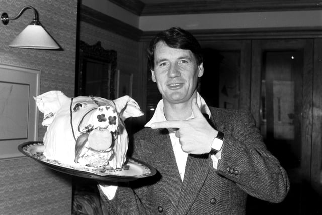 British actor and documentary-maker Michael Palin with a cake in the shape of a pig's head, promoting his new film 'A Private Function' at the King Ames Hotel in Edinburgh in April 1985.