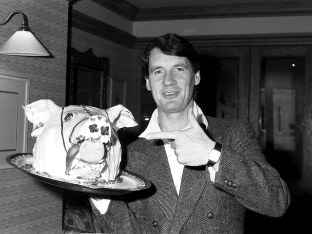 British actor and documentary-maker Michael Palin with a cake in the shape of a pig's head, promoting his new film 'A Private Function' at the King Ames Hotel in Edinburgh in April 1985.