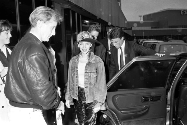Australian pop singer Kylie Minogue smiles for the photographer before getting into her car in Edinburgh airport in October 1989.