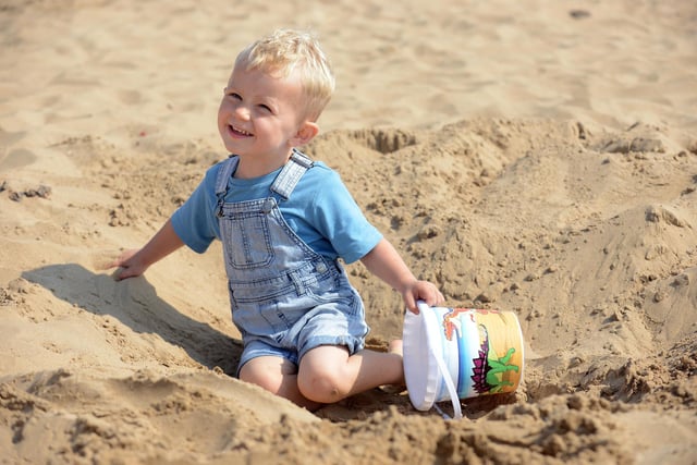 Two-year-old Hugo sits in his sand hole at Seaton Carew beach.