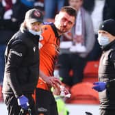 Dundee United's Ryan Edwards goes off injured after a challenge by Hearts' Ellis Simms.