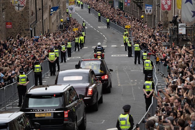 Police stand guard as the Queen's coffin travels down the Royal Mile in Edinburgh