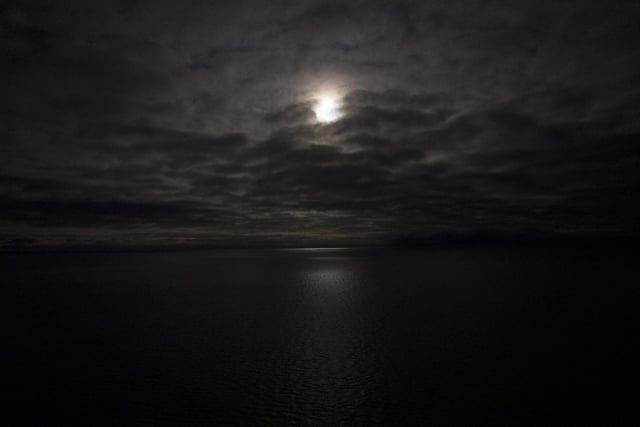The first full moon of the year lights the ocean in Svalbard, Norway, Saturday, Jan. 7, 2023.