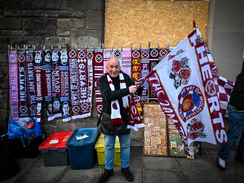 A vendor sells merchandise outside the stadium (Photo by ANDY BUCHANAN / AFP via Getty Images)