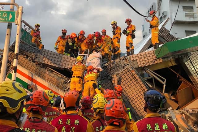 This handout photo taken and released  by the Taitung County Fire Bureau shows firefighters moving a person during a rescue operation at the site of a collapsed building (via Getty Images)