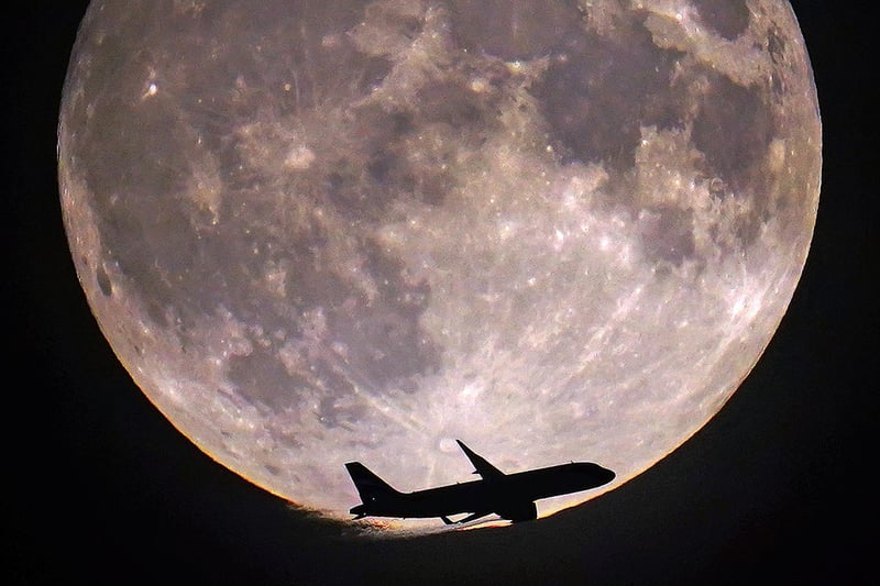 A plane passes the super blue moon in London.